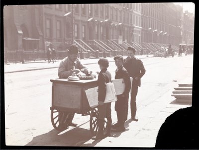Vista de un vendedor de helados en la calle, con tres niños vendedores de periódicos comprando helado, Nueva York, c.1901 de Byron Company